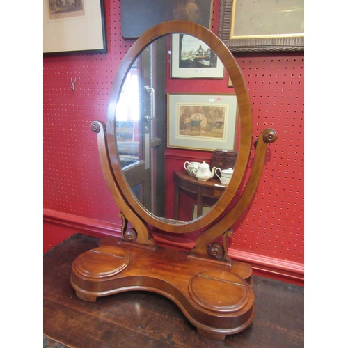 4111 - A mid-Victorian mahogany oval dressing chest tilting mirror on scroll supports and serpentine front ... 