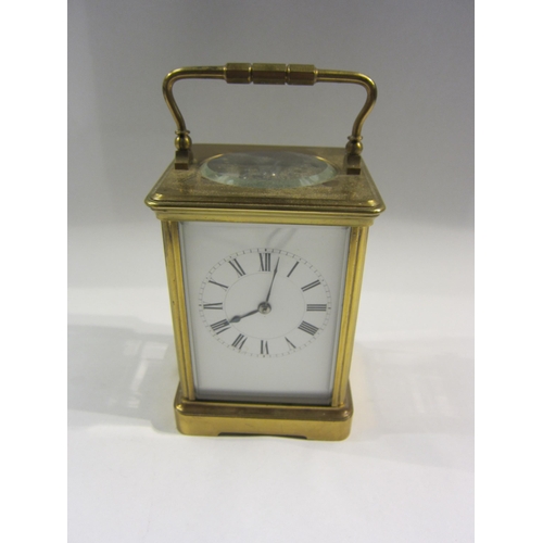 4382 - A brass carriage clock, enamel Roman numeral dial, with key, 13cm tall