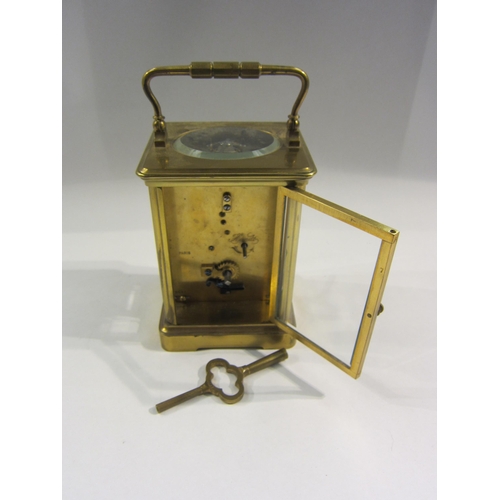 4382 - A brass carriage clock, enamel Roman numeral dial, with key, 13cm tall