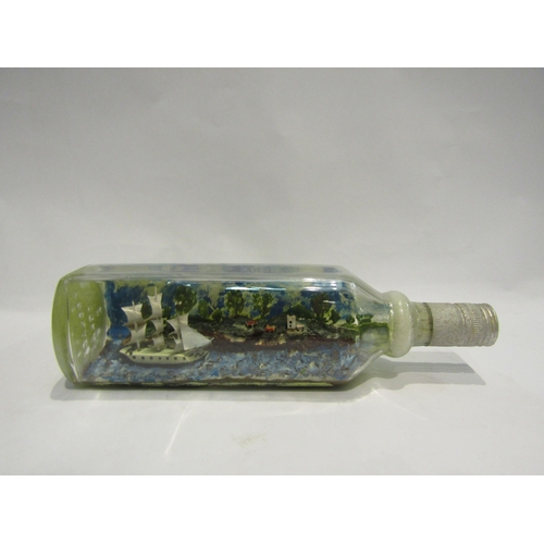 4422 - A ship in a bottle, sail boat with dwellings on cliffs, 28cm long