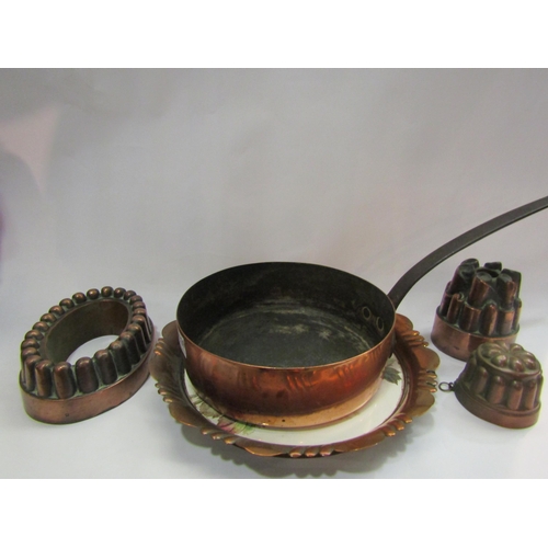 4329 - A quantity of jelly moulds together with a pan and asethic plaque with copper rim