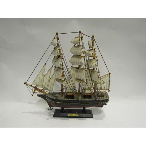 4418 - A model of the Cutty Sark, 32cm long, and four glass ships in bottles