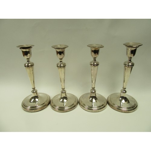 6383 - A set of four John Parsons & Co Georgian silver candlesticks with weighted bases, faint crested deta... 