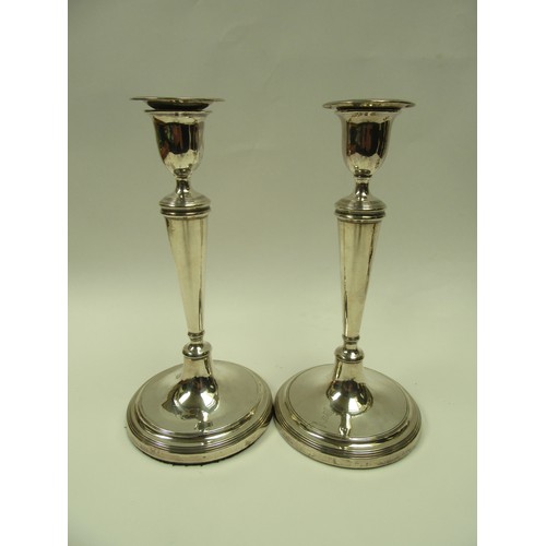 6383 - A set of four John Parsons & Co Georgian silver candlesticks with weighted bases, faint crested deta... 