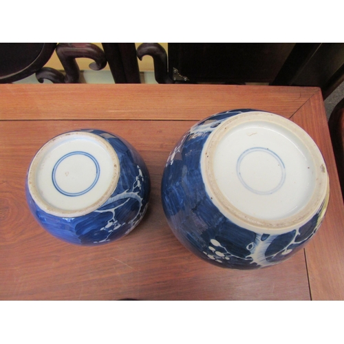 1089 - Two Oriental blue and white prunus design ginger jars with covers, blue rings to base of each, talle... 