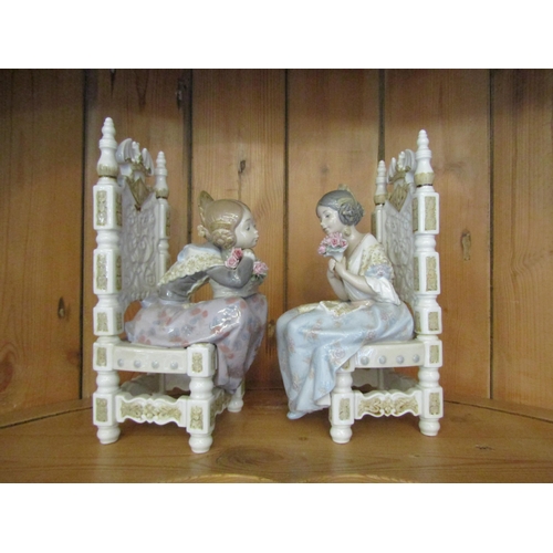 1008 - A pair of Lladro figurines, seated Spanish girls holding bouquets, one marked Daisa 1982, 27cm tall