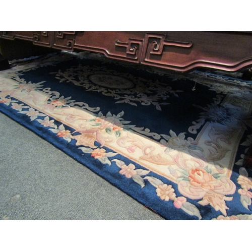 1658 - A Chinese rug, blue ground with pink floral border design. 198x137cm