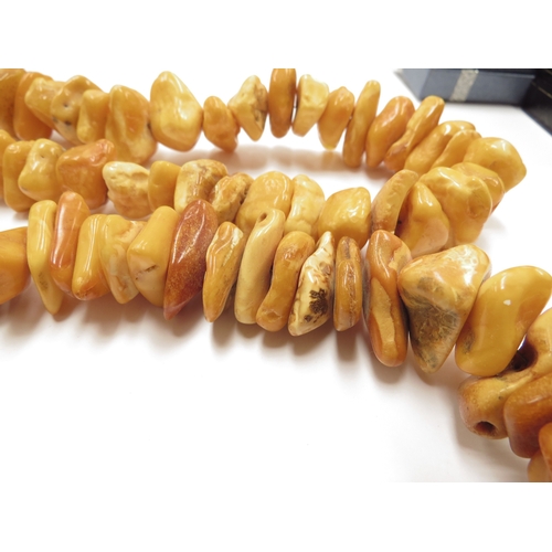 6097 - Two irregular shaped amber bead necklaces, 70cm and 80cm long approx, 308g total