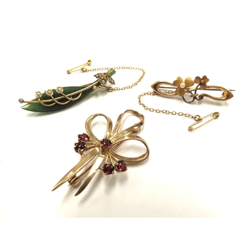 6112 - A 9ct gold bow brooch, 5.3g, a 15ct gold bar brooch, 2.8g and a 9ct gold framed jade brooch with app... 