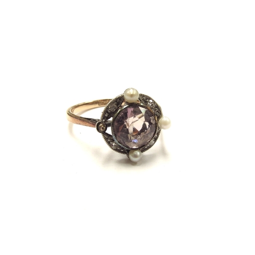 6104 - A gold ring set with a circular pale pink stone framed with old cut diamonds in milgrain setting spa... 