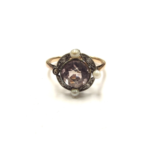 6104 - A gold ring set with a circular pale pink stone framed with old cut diamonds in milgrain setting spa... 