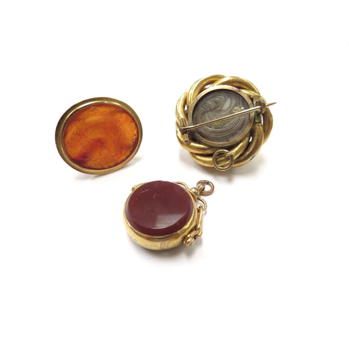 6131 - A carved cornelian intaglio fob in unmarked gold, a 9ct gold cornelian and bloodstone swivel fob and... 