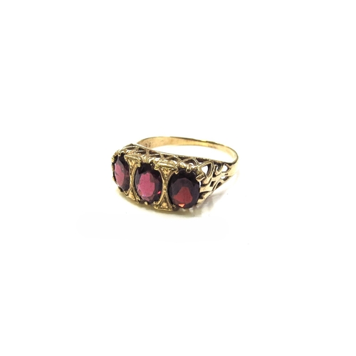 6208 - A 9ct gold three stone garnet ring. Size R, 3.2g