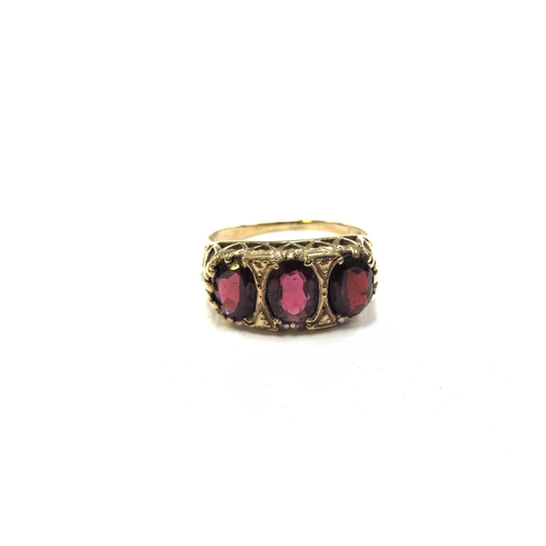 6208 - A 9ct gold three stone garnet ring. Size R, 3.2g