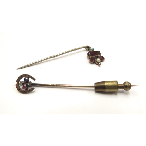 6101 - Two stick pins, one horseshoe finial with diamond, sapphire and ruby clover to centre, and a garnet,... 