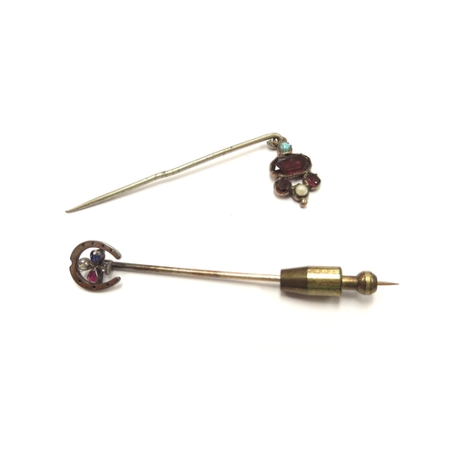 6101 - Two stick pins, one horseshoe finial with diamond, sapphire and ruby clover to centre, and a garnet,... 