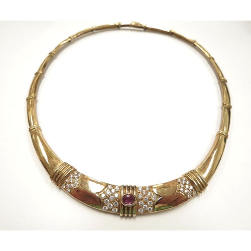 6113 - A gold necklace with articulated long links, centrally set with an oval ruby flanked by clusters of ... 