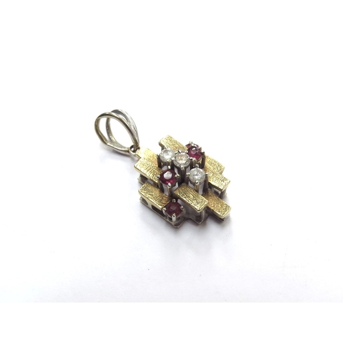 6098 - A two tone gold abstract design pendant set with rubies and diamonds, stamped 750, 3.5g