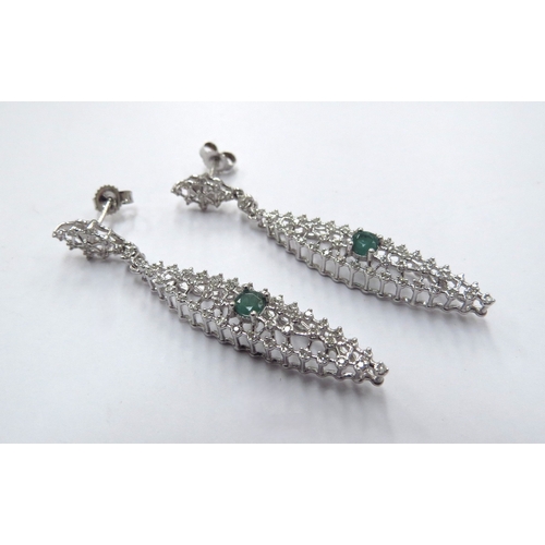 6167 - A pair of white gold diamond and emerald set wirework drop earrings, 5cm drop, 4.5g