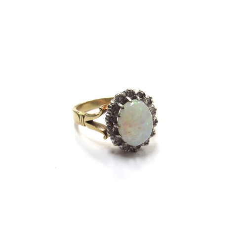 6118 - An opal and diamond ring, the opal 9mm x 7mm framed by diamonds, stamped 18ct. Size O, 5.8g