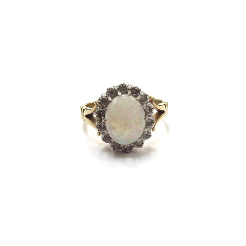 6118 - An opal and diamond ring, the opal 9mm x 7mm framed by diamonds, stamped 18ct. Size O, 5.8g