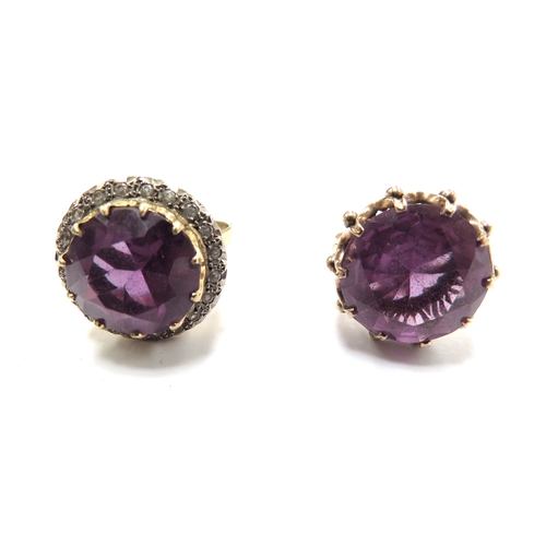 6070 - Two unmarked gold dress rings, both with a large amethyst coloured stone one framed by clear stones,... 