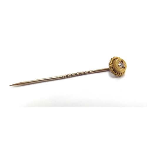 6072 - A gold stick pin stamped 15ct with a diamond set finial, 1.4g