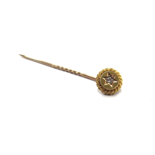 6072 - A gold stick pin stamped 15ct with a diamond set finial, 1.4g