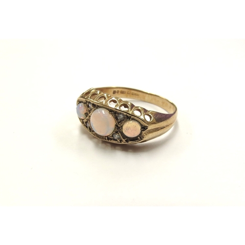 6369 - A 9ct gold opal and diamond chip ring, the three round opals spaced by diamond chips. Size I/J, 1.6g