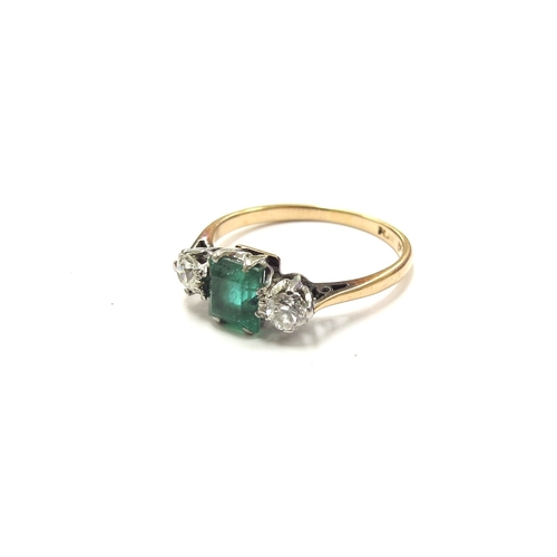 6314 - An emerald and diamond ring, the central emerald 5mm x 4mm flanked by diamonds, marked 18ct. Size L,... 