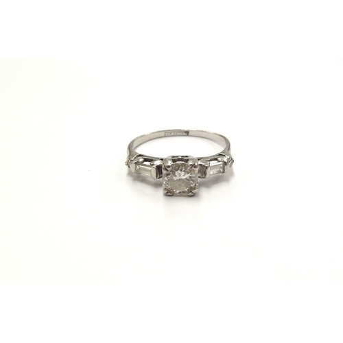 6019 - A platinum set diamond solitaire ring, 0.50ct approx flanked by round cut and baguette cut diamonds.... 