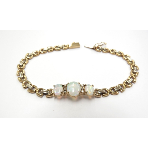 6054 - A gold bracelet set with three oval opals spaced by clear white stones, stamped 14k, 18cm long, 8.4g