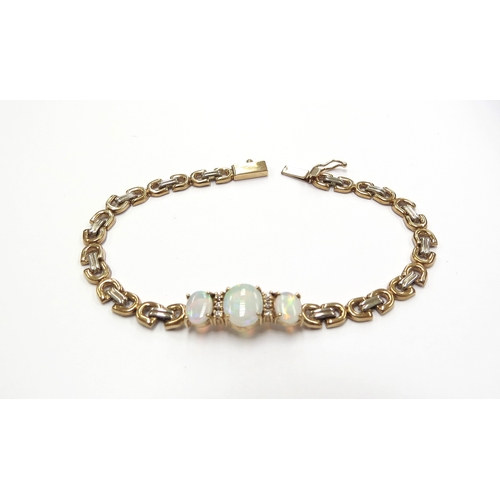 6054 - A gold bracelet set with three oval opals spaced by clear white stones, stamped 14k, 18cm long, 8.4g