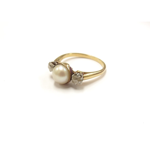 6036 - A gold ring centrally set with a pearl flanked by old cut diamonds, stamped 18ct. Size P, 3.5g