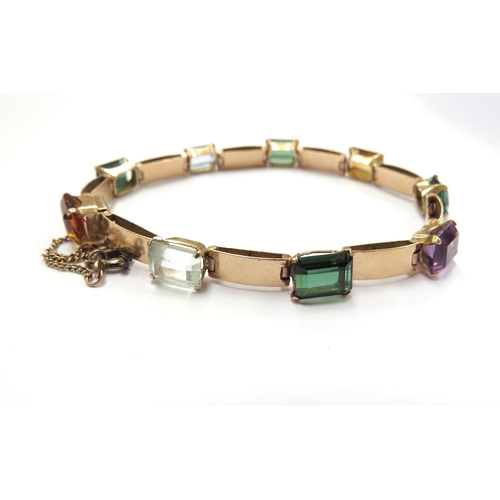 6056 - A gold bracelet set with multi-coloured gems, 18cm long, unmarked, 11.7g