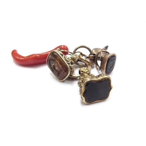 6035 - A coral pendant on a snake jump ring with watch key and three intaglio fobs, all unmarked