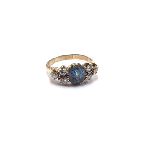 6050 - A gold ring centrally set with an oval blue topaz flanked by three old cut diamonds, stamped 18ct. S... 