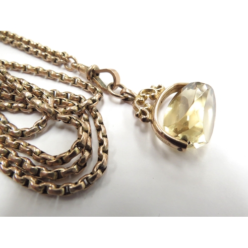 6032 - A gold guard chain stamped 9ct, 151cm long hung with a citrine swivel fob, 38.3g total