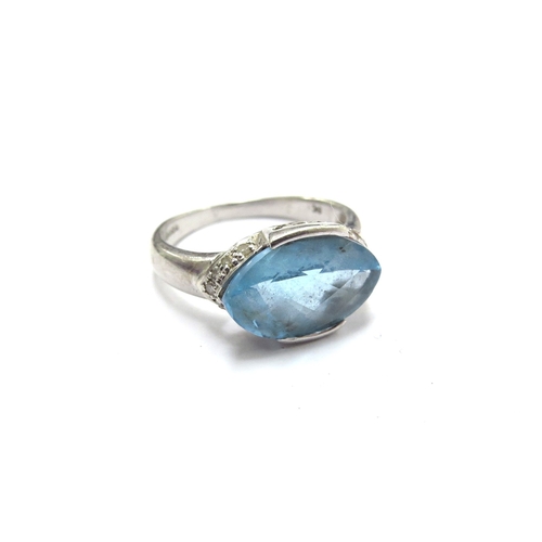 6039 - A 9ct white gold ring with elliptical facet cut blue topaz and diamonds to outer. Size P/Q, 4.1g