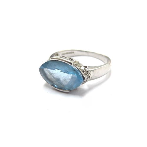 6039 - A 9ct white gold ring with elliptical facet cut blue topaz and diamonds to outer. Size P/Q, 4.1g