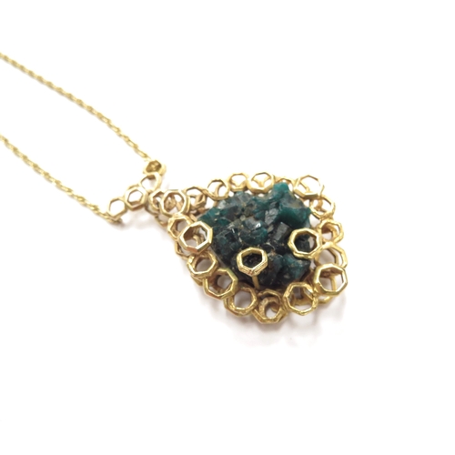 6192 - A 9ct gold pendant set with a rough dioptase crystal framed in abstract honeycomb mount hung on rope... 