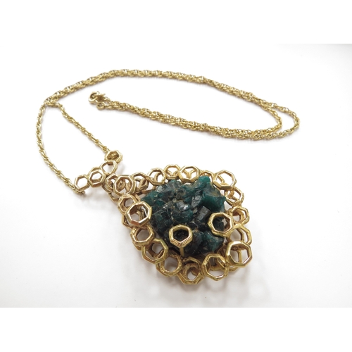 6192 - A 9ct gold pendant set with a rough dioptase crystal framed in abstract honeycomb mount hung on rope... 