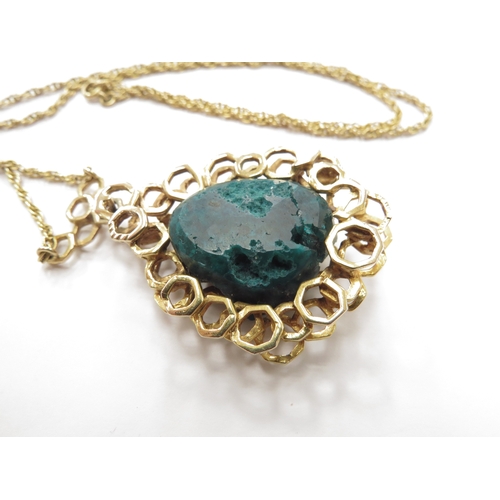 6192 - A 9ct gold pendant set with a rough dioptase crystal framed in abstract honeycomb mount hung on rope... 