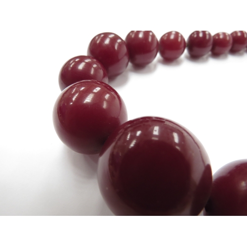 6080 - A cherry amber/Bakelite bead necklace, 41cm long