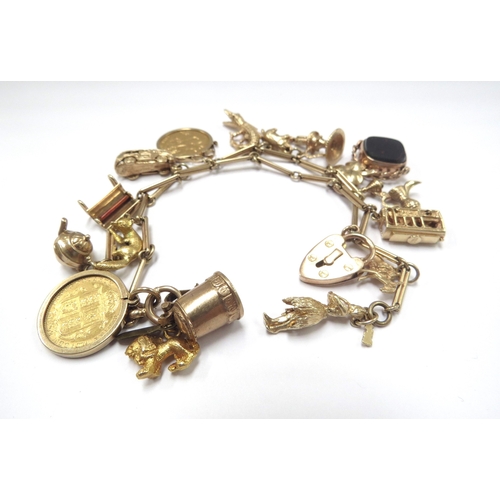 6058 - A gold charm bracelet made from a watch chain stamped 9ct hung with various charms including 9ct and... 