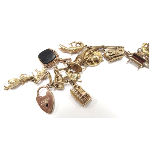 6058 - A gold charm bracelet made from a watch chain stamped 9ct hung with various charms including 9ct and... 