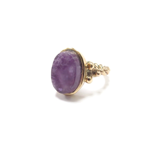 6121 - An unmarked gold ring with twisted design shank set with an oval flat cut amethyst. Size J, 4.6g