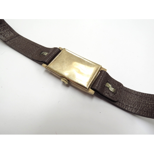 6348 - A 9ct gold cased Record wristwatch on brown leather strap, 24.3g total