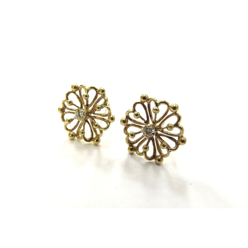 6258 - A pair of 18ct gold floral shaped earrings with single diamond to centre, 2g (no backs)