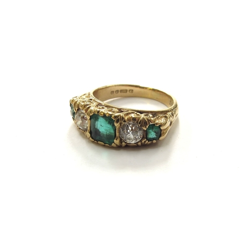 6281 - An 18ct gold ring with carved scroll shaped head, set with three graduated step cut emeralds (one ch... 